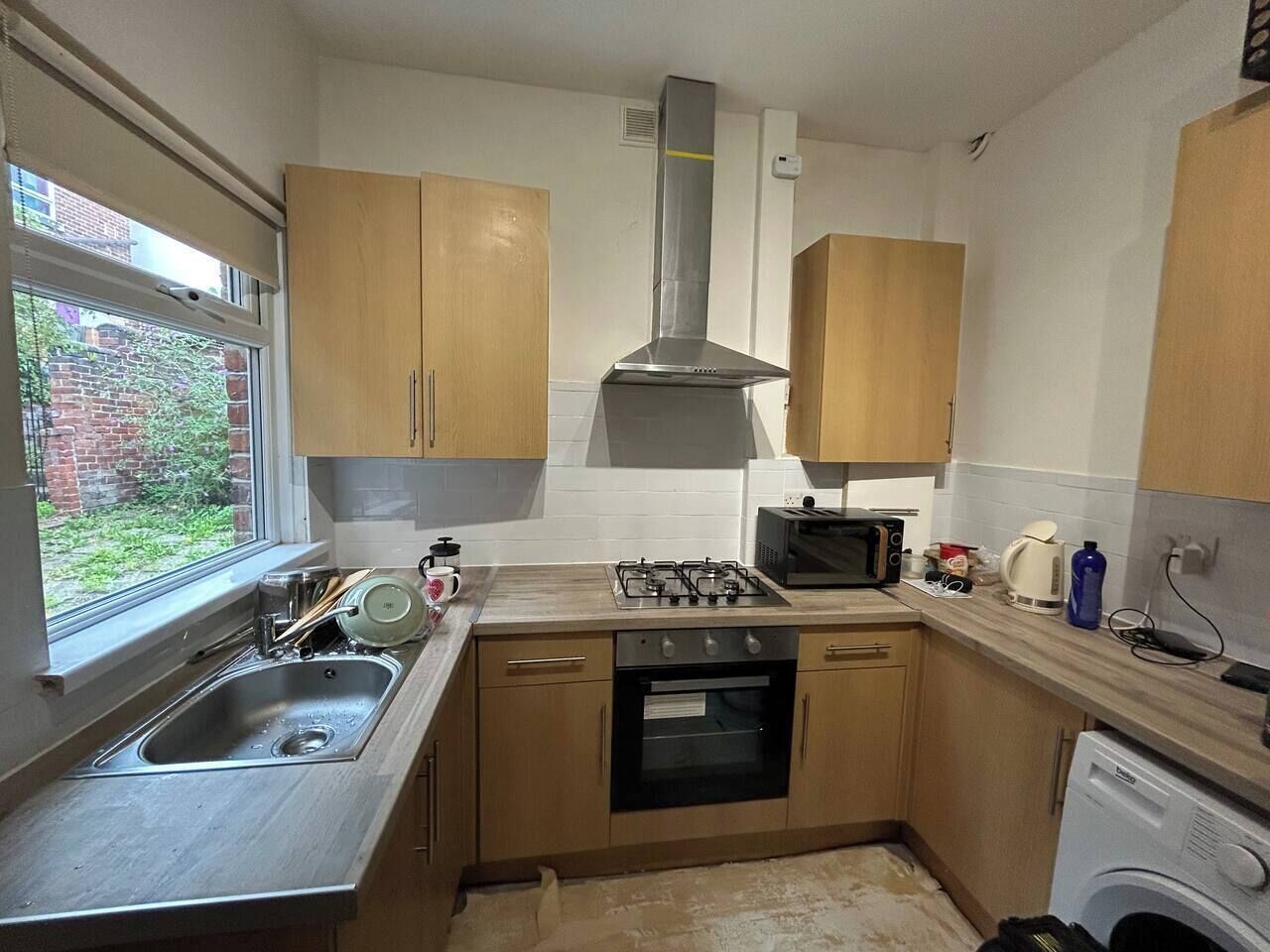 A compact kitchen with a sink, stove, microwave, and oven.