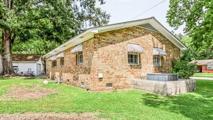 A single-story brick house with a covered porch, a small attached garage, and a well-maintained lawn. - Charming Single-Family Home (Greenville)