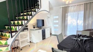 Ein Hotelzimmer mit Treppe, Fernseher, Schreibtisch und Bett.