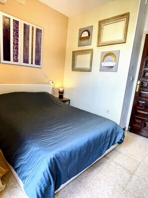 A bedroom with a bed, a nightstand, a wall-mounted lamp, and framed artwork. - House with 2 bedrooms and a shared pool (Empuriabrava)