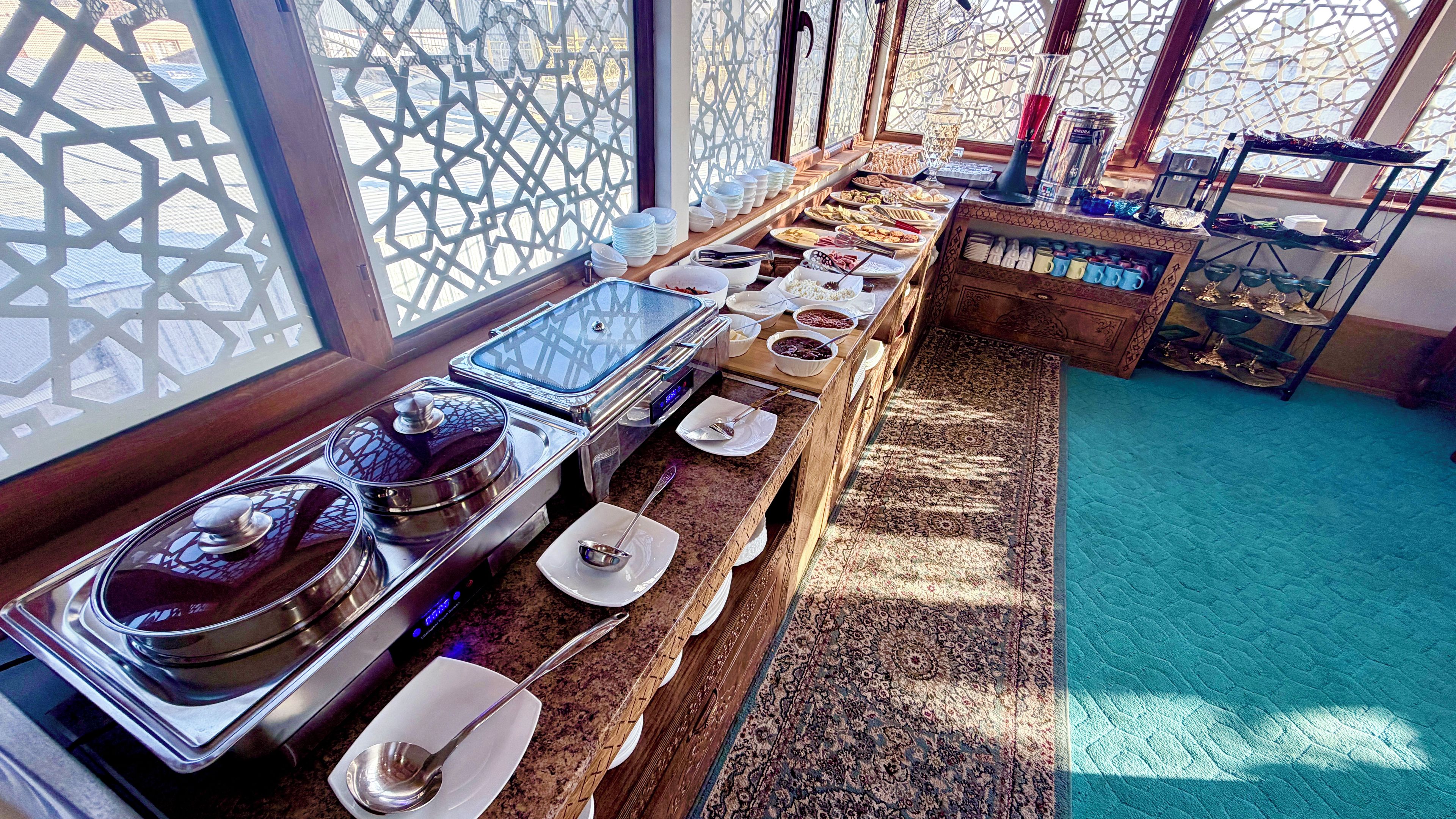 A buffet setup with various food items and utensils.