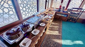 A buffet setup with various food items and utensils. - LOLA Boutique Hotel (Bukhara)