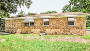 A two-story brick building with a flat roof, a front porch, and a small front yard. - Charming Single-Family Home (Greenville)