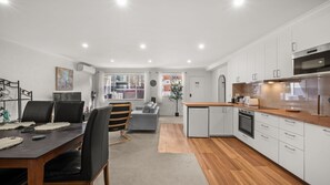 A modern kitchen with white cabinets, a wooden countertop, and stainless steel appliances. - Chase & Chill  stay in Phillip! (Phillip)