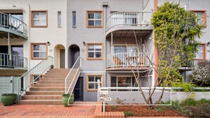 Un edificio residencial de varios pisos con escaleras, balcones y buzones.