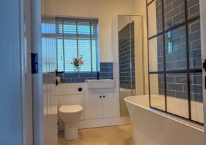 Une salle de bain avec des toilettes, un lavabo et une baignoire.