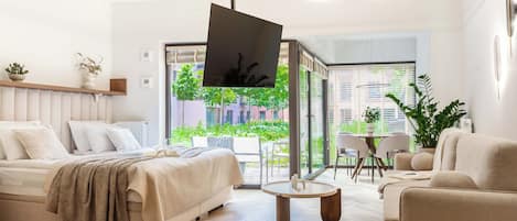Una sala moderna con un sofá, una mesa de centro y un televisor montado en la pared.