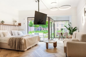 Ein modernes Wohnzimmer mit einer Couch, einem Couchtisch und einem an der Wand befestigten Fernseher.