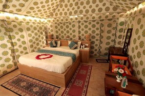 A bedroom with a bed, nightstands, a chair, a mirror, and patterned walls. - The Sandy Resort  (Sam)