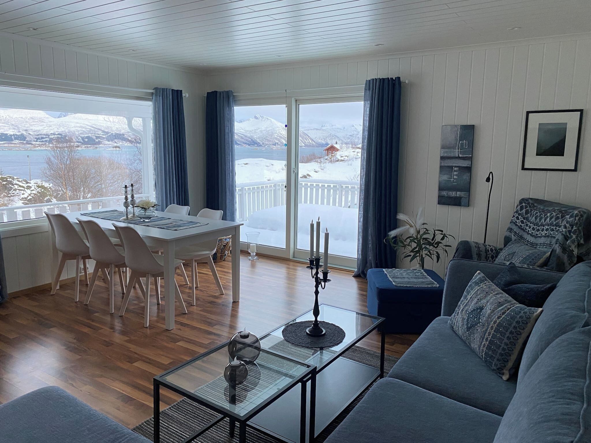 A spacious living room with a large window, a dining area, and a sofa.