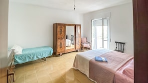 Ein Schlafzimmer mit Bett, Nachttisch, Kleiderschrank und Stuhl.