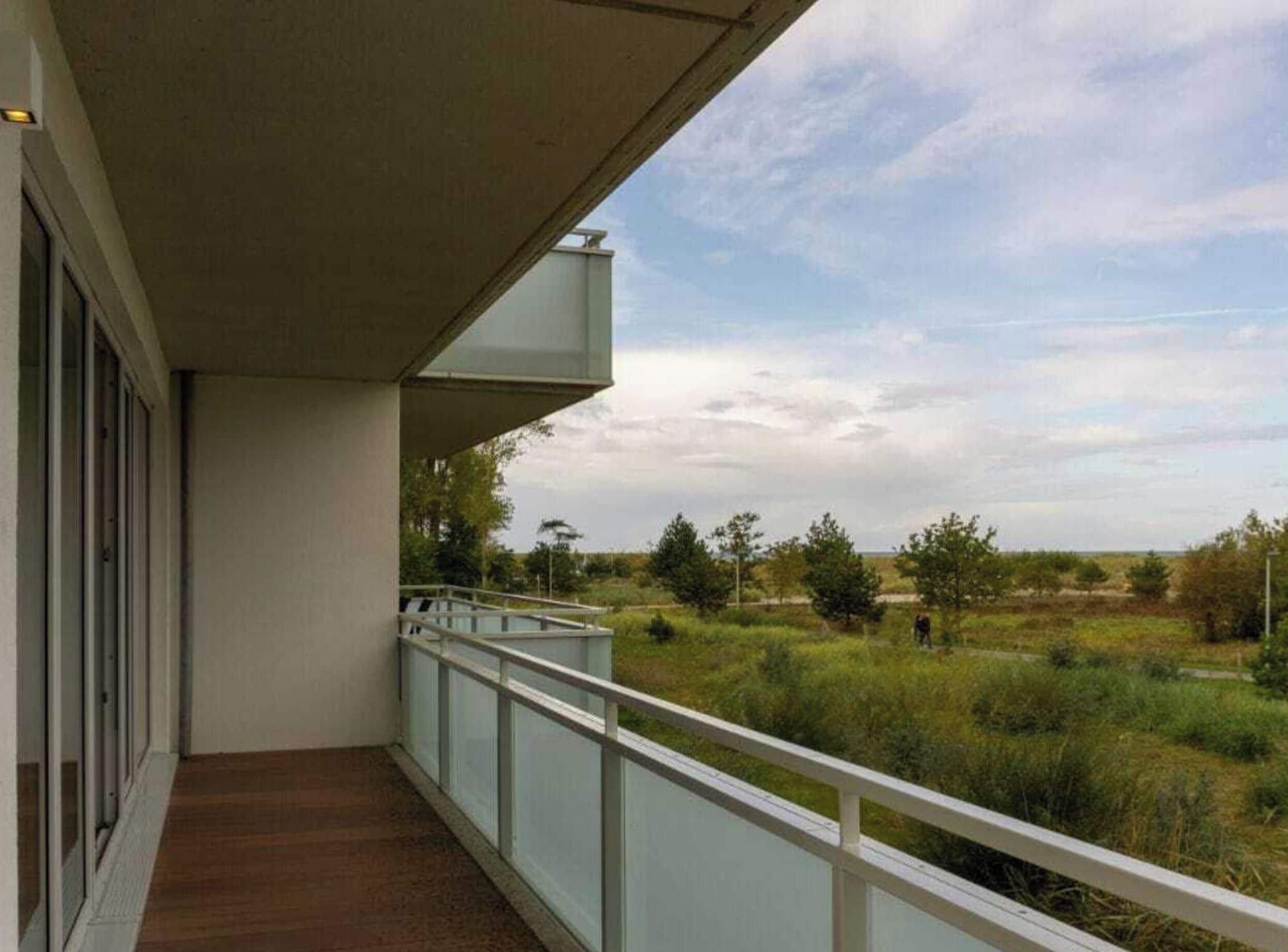 Un balcón con vistas a un paisaje cubierto de césped y árboles.