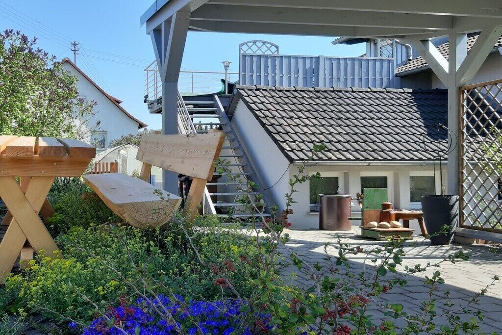 Ein Innenhof mit einer Holzbank, einer Treppe und einem Ziegeldach.