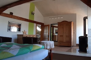 Un dormitorio con cama, armario de madera y una mesita.