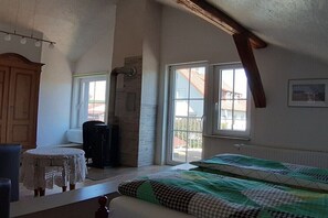 A room with a bed, a small table, a cabinet, and a window. - In the Old Schoolhouse (Schrozberg)