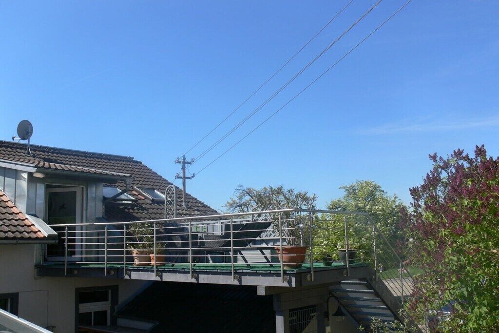 Ein Wohngebäude mit Balkon, Satellitenschüssel und Stromleitung.