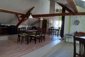 A dining area with wooden furniture and a high ceiling with exposed beams.
