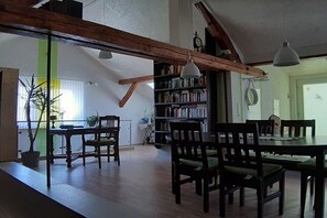 Ein Essbereich mit Holzzmöbeln, einem Bücherregal und einer Hängelampe.