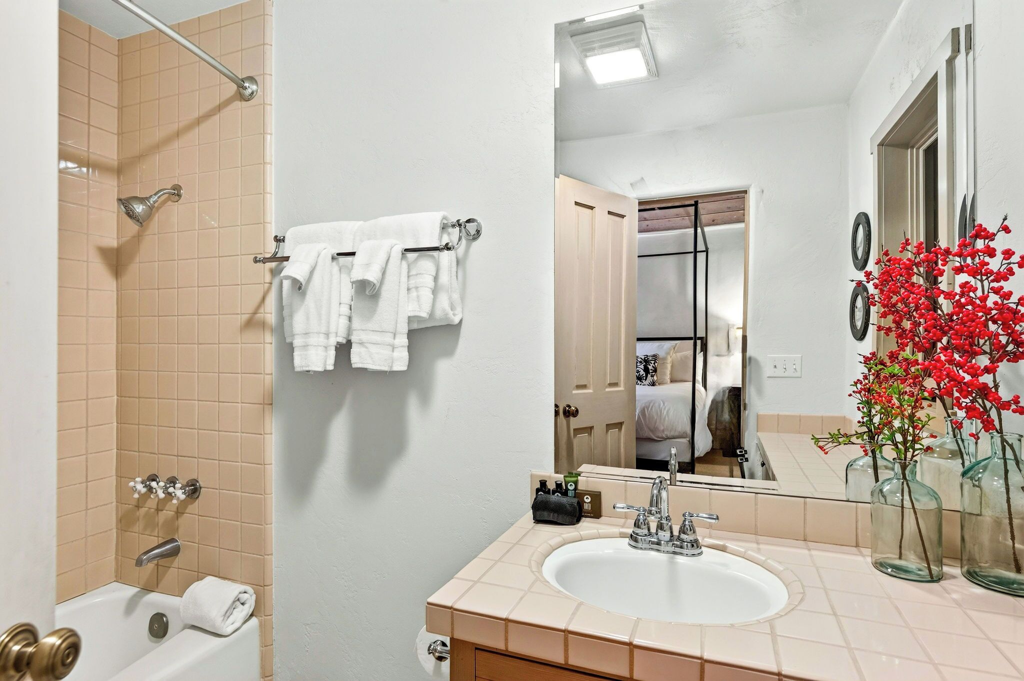 A bathroom with a bathtub, a sink, and a mirror.