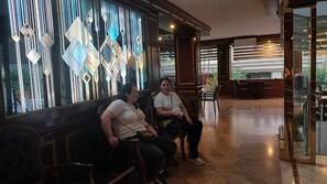 A lobby with a seating area, a glass wall with geometric patterns, and a view of the outdoors. - Hotel Çağyiğit (İstanbul)
