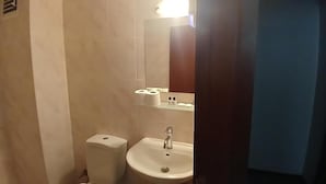 Ein Badezimmer mit Toilette, Waschbecken und Spiegel.
