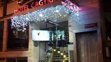 L'entrée d'un hôtel, avec une enseigne indiquant « HÔTEL CAGYIGIT », et un escalier menant à l'entrée.