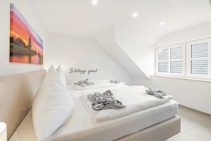 Ein Schlafzimmer mit einem Bett, Kissen und einem Bild an der Wand.