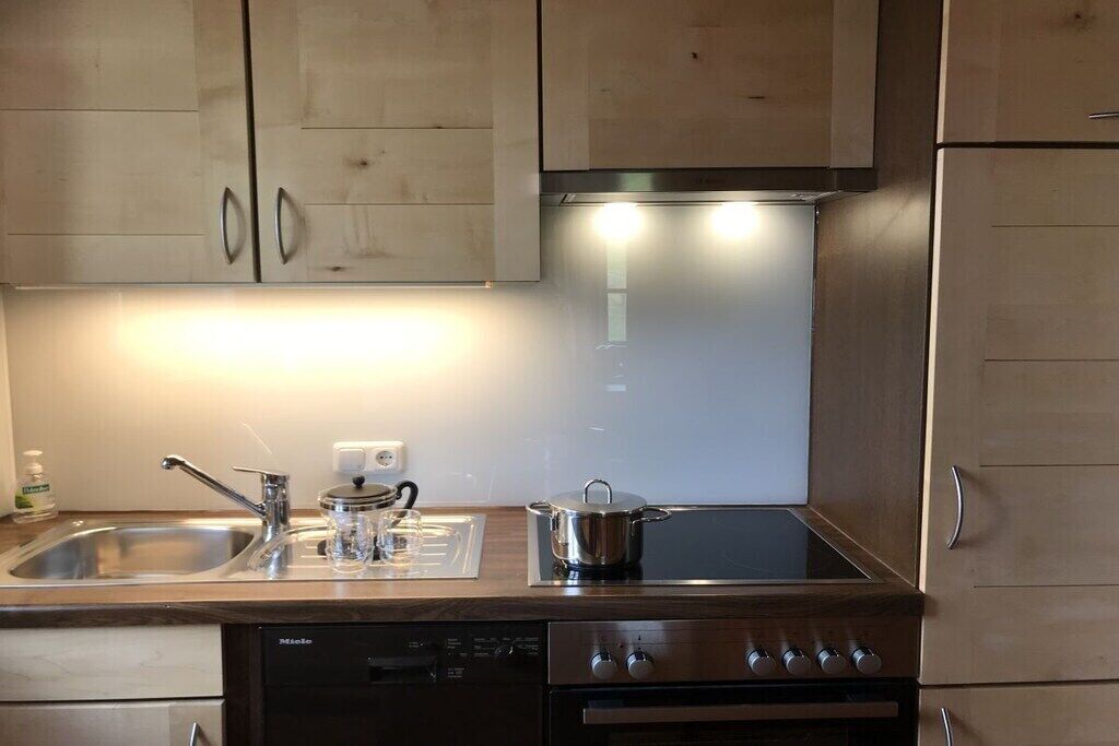 Een koffiezetapparaat/waterkoker, een koelkast, een oven, een kookplaat