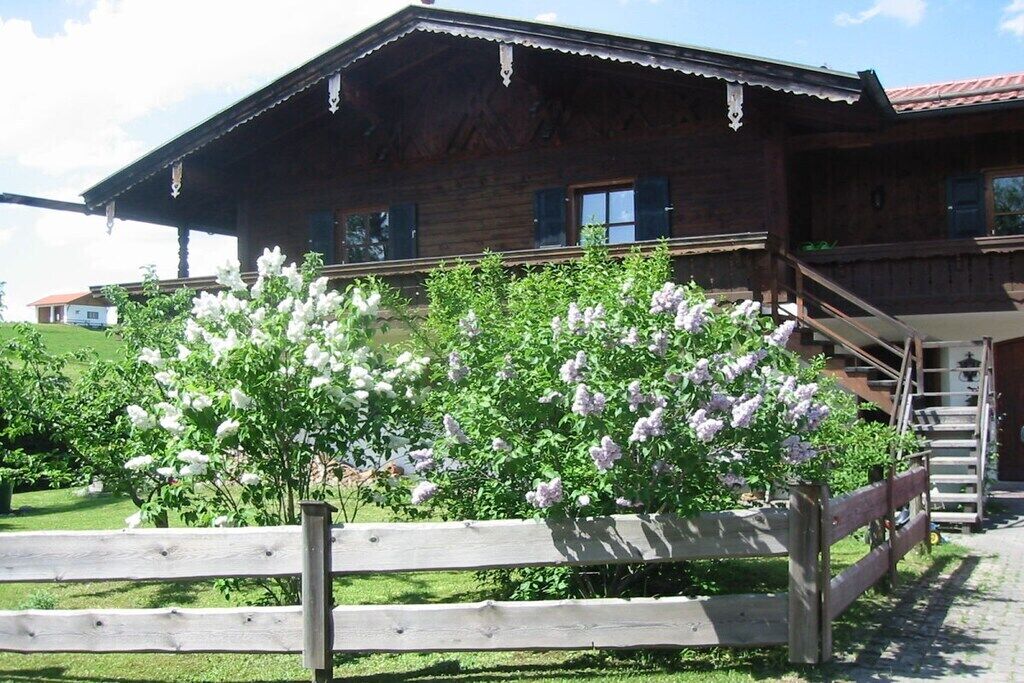 A wooden building with a porch and a staircase leading to the entrance.