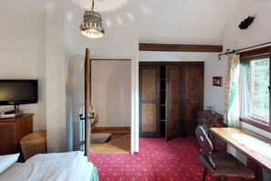 Ein Zimmer mit einem Bett, einem Schreibtisch, einem Fernseher und einem Kleiderschrank.