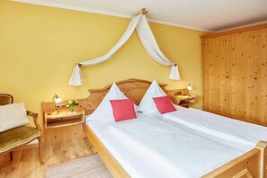 A room with a bed, a nightstand, a lamp, and a wooden wardrobe. - Fellhorn in the Auffenberg guesthouse (Fischen)