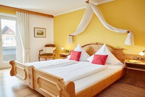 A double bed with a canopy, bedside tables, a chair, and a window with curtains. - Fellhorn in the Auffenberg guesthouse (Fischen)