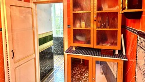 A bathroom with a tiled floor, a sink, a cabinet with glass doors, and a mirror.