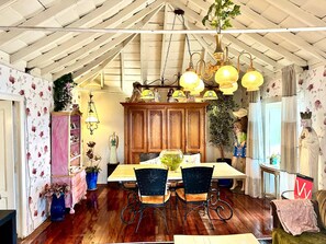 A dining area with a wooden table, chairs, and hanging light fixtures.