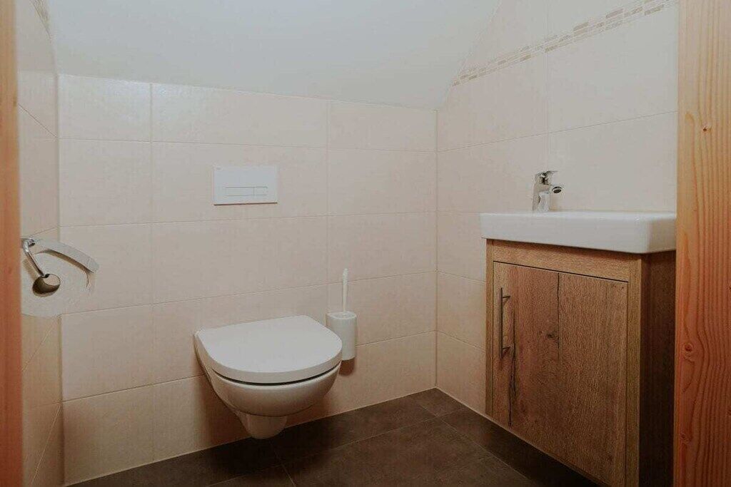 A small bathroom with a toilet, a sink, and a cabinet.