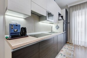 A modern kitchen with a built-in stove, a microwave, and a coffee machine. - Vatican Flat 2 Bedrooms 2 Ensuite Baths (Roma)