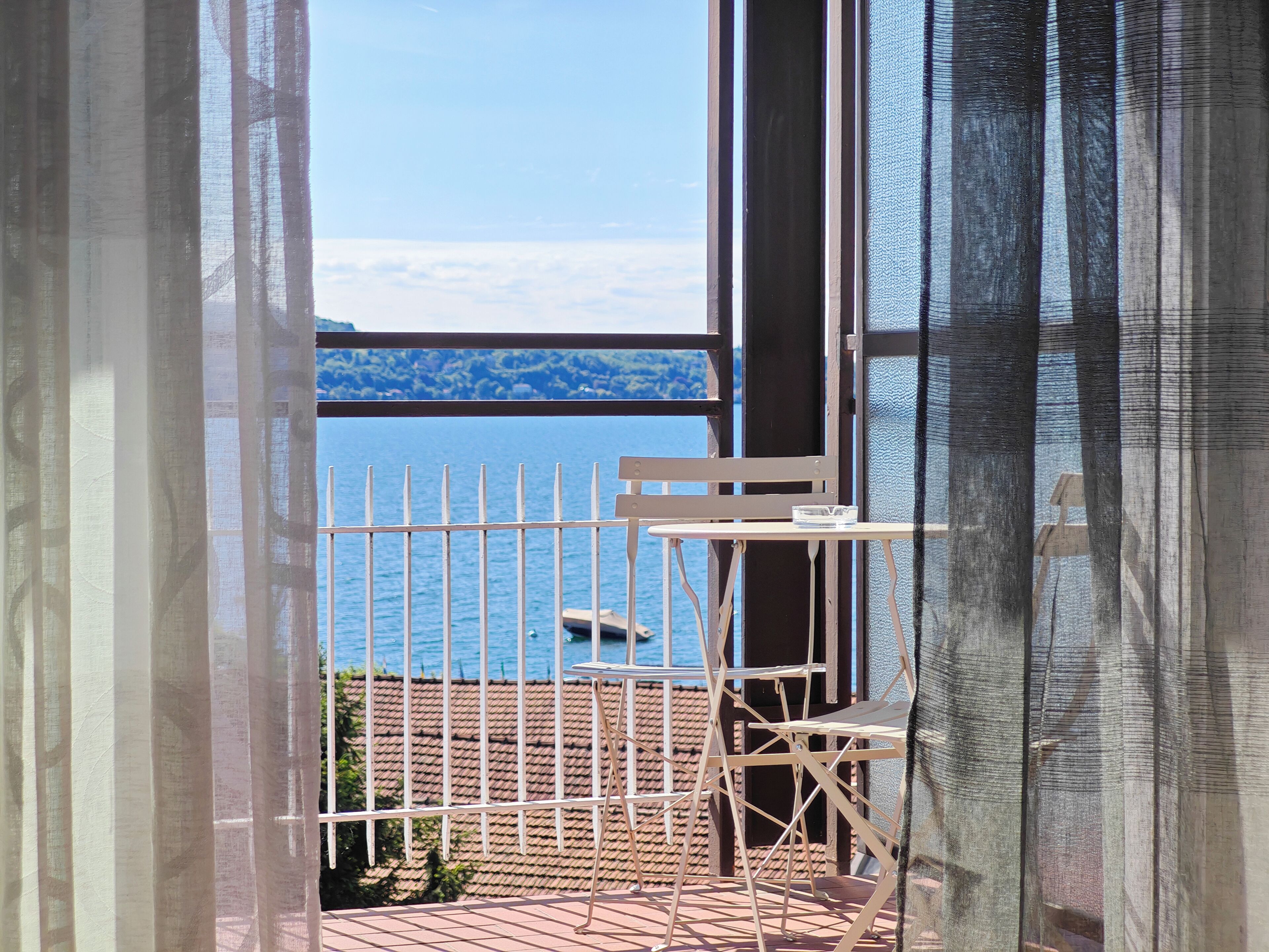 Ein Balkon mit Blick auf ein Gewässer und ein entferntes Land.