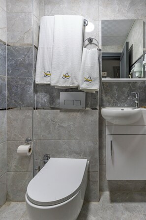 Un bagno moderno con WC, lavabo e portasciugamani.
