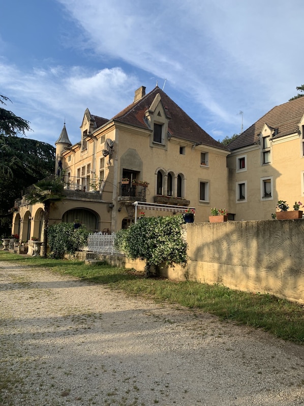 Un edificio grande e histórico con varias alas y una torre destacada.
