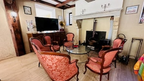 A traditional living room with a fireplace, wooden furniture, and a television.
