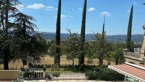 Una piscina con una vista despejada del paisaje circundante, incluyendo árboles altos y colinas al fondo.