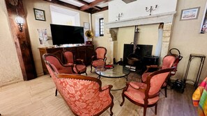 Un salón tradicional con chimenea, muebles de madera y un televisor.