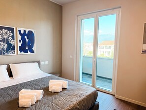 Ein Hotelzimmer mit einem Bett, einem großen Fenster und Kunstwerken an der Wand.