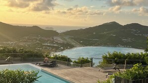 Ein Poolbereich mit Blick auf das Meer und die Berge.