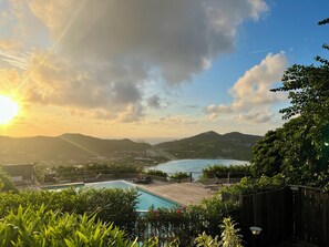A pool area with a view of the sea and mountains.