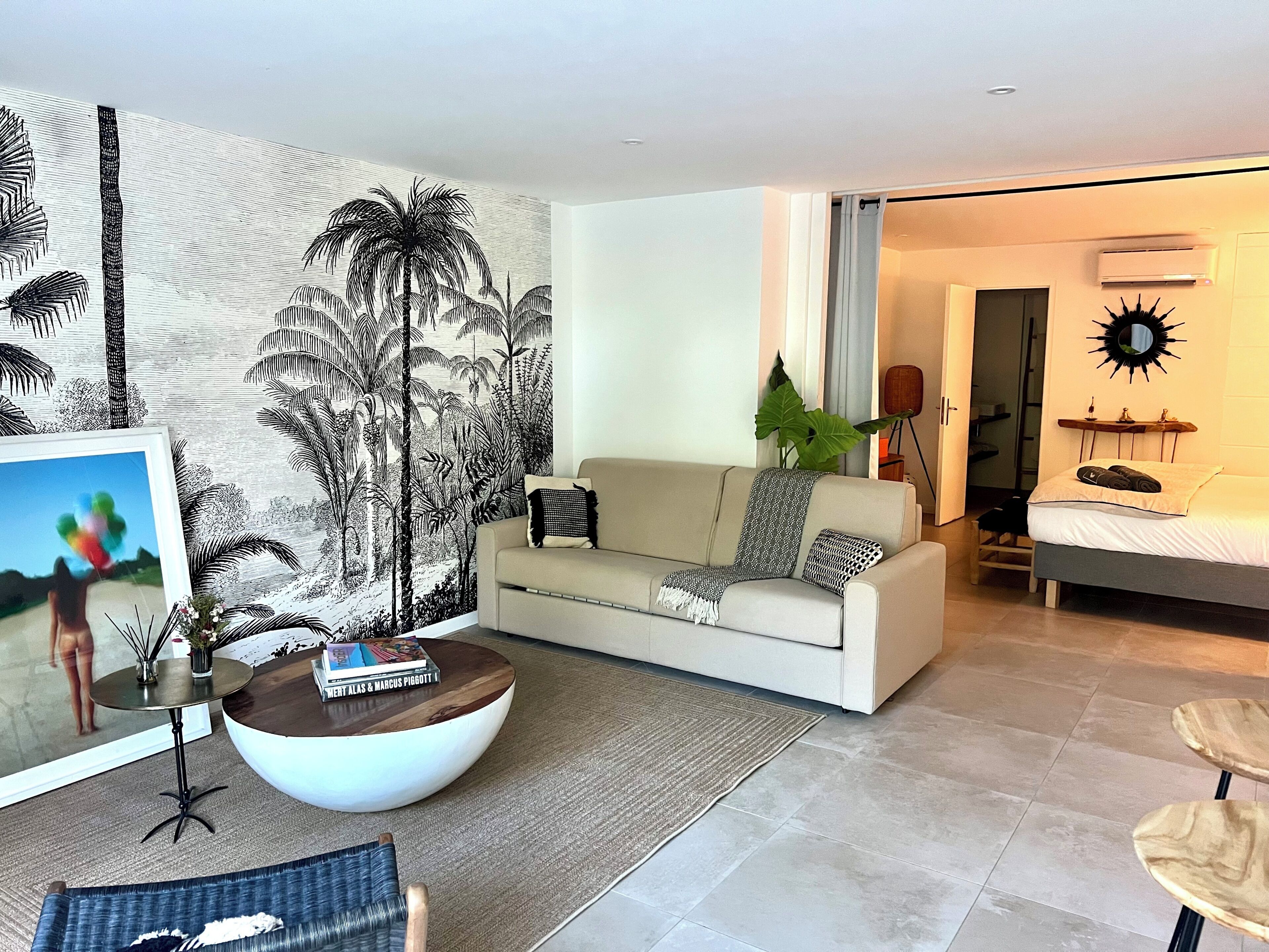 Un salon moderne avec un canapé, une table basse et une grande fresque murale.
