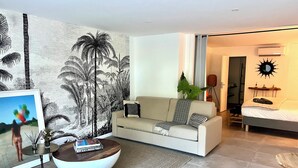 Ein modernes Wohnzimmer mit einer Couch, einem Couchtisch und einer großen Wandmalerei.