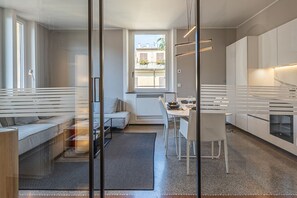 Een moderne keuken met een eethoek, een inbouwoven en een raam dat voor natuurlijk licht zorgt.