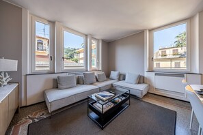 Een moderne woonkamer met een bank, een salontafel en grote ramen.