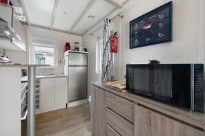 Een moderne keuken met een ingebouwde magnetron, een koelkast en een raam met uitzicht.